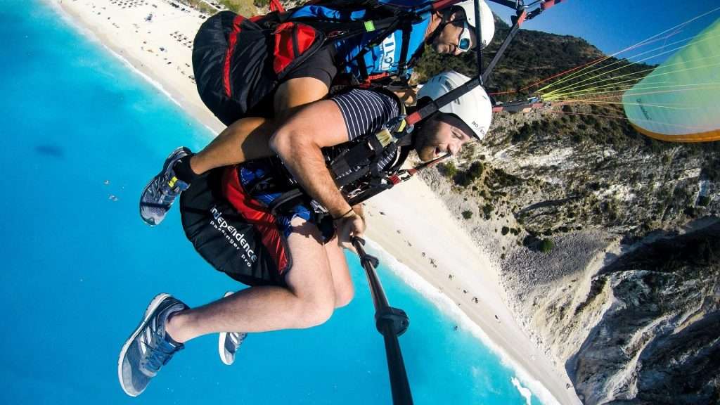 Thrilling paragliding adventure in Myrtos, Greece – Experience unforgettable moments as a man enjoys exhilarating paragliding, showcasing the best activities in Kefalonia, Greece.