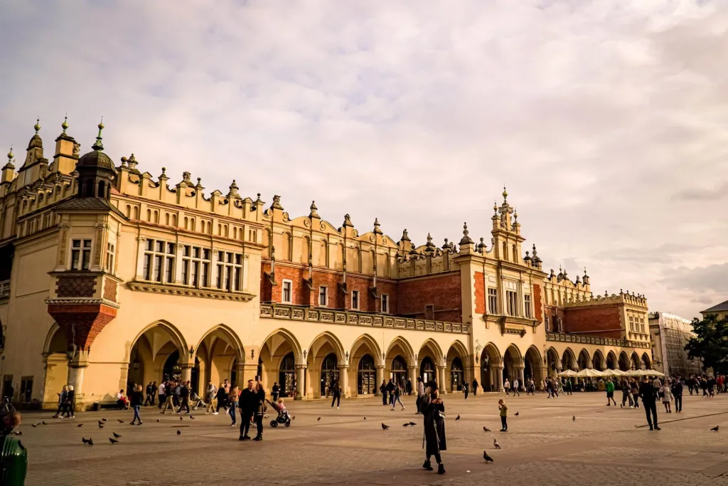 The architecture of the Fabric Hall impresses in the middle of the central square, with a multitude of people wandering in front of it.