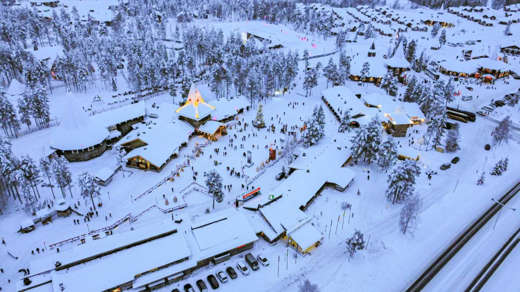 Panoramic view of Santa Claus Village. A pristine, snow-covered landscape with illuminated cottages.